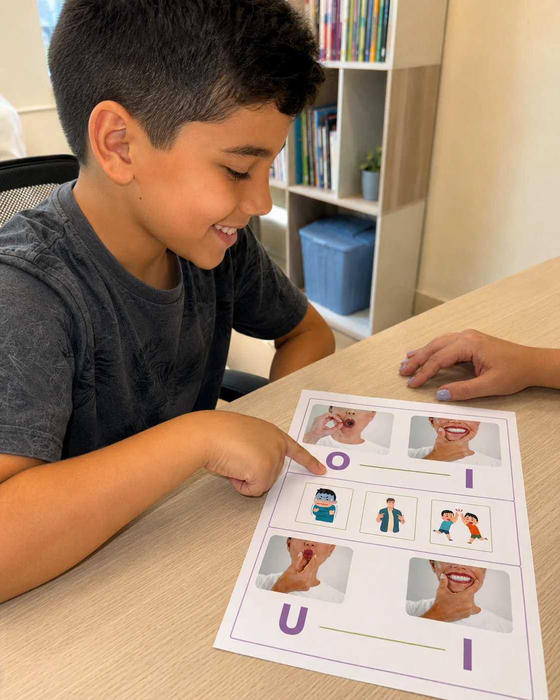 Criança em idade escolar apontando e lendo a página de vogais do caderno, com a profissional ao lado